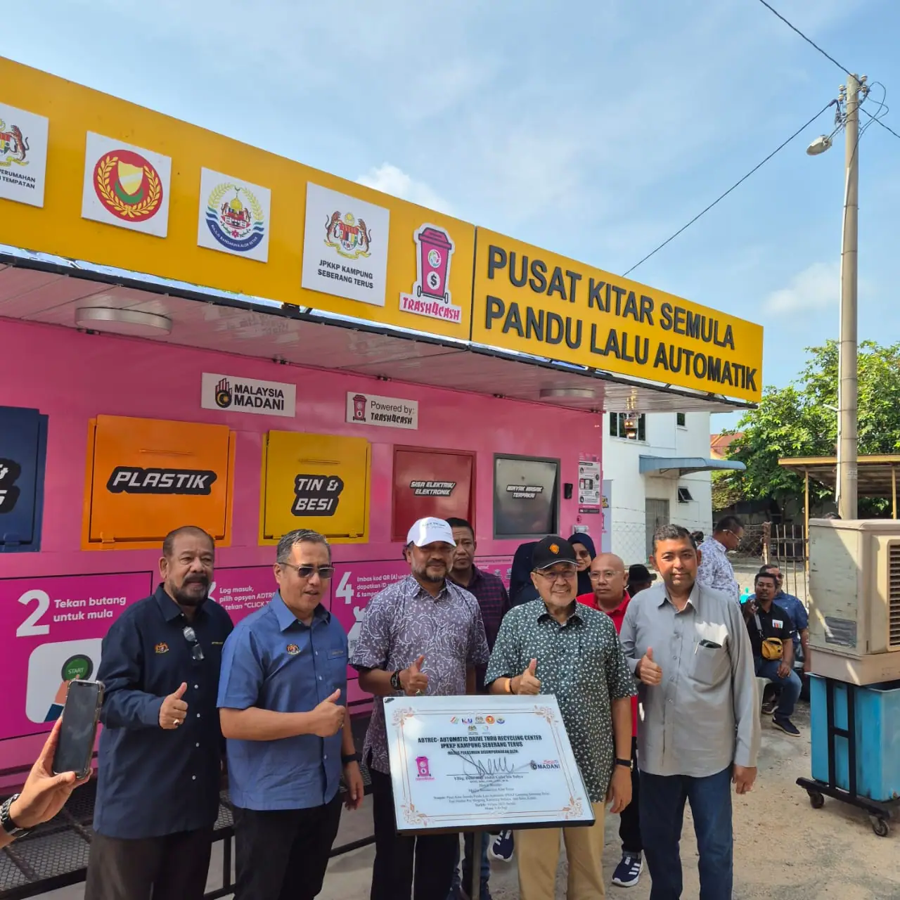 Officials at a pink Trash4Cash automatic drive-thru recycling centre